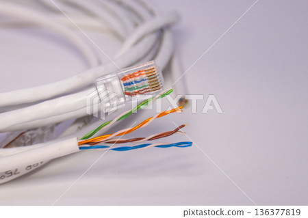 Ethernet cable with exposed colored wires and RJ45 plug, showing network wiring detail and internet connection setup 136377819