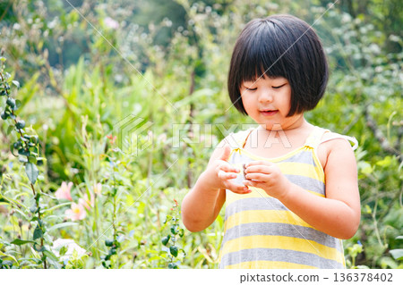 一個留著波波頭、活潑好動的女孩在大自然中玩耍 136378402