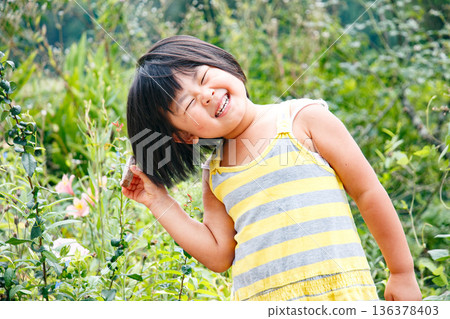 一個留著波波頭、活潑好動的女孩在大自然中玩耍 一個留著波波頭、活潑好動的女孩在大自然中玩耍 136378403