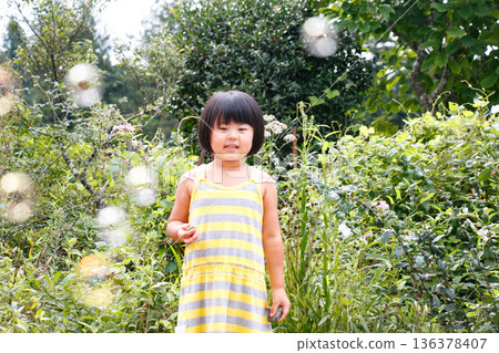 一個留著波波頭、活潑好動的女孩在大自然中玩耍 136378407