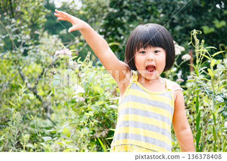 一個留著波波頭、活潑好動的女孩在大自然中玩耍 136378408