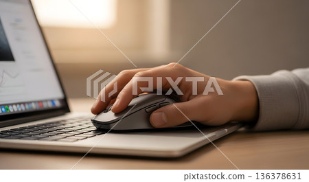 Close up hand using computer mouse on laptop keyboard for productive work or browsing 136378631
