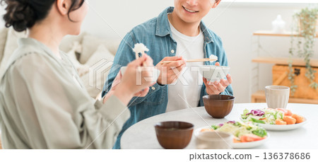 一對年輕的亞洲夫婦在家中餐桌上用餐。 136378686