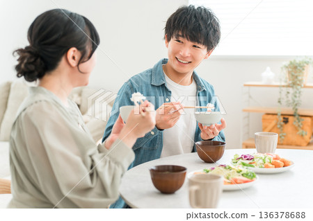 一對年輕的亞洲夫婦在家中餐桌上用餐。 136378688