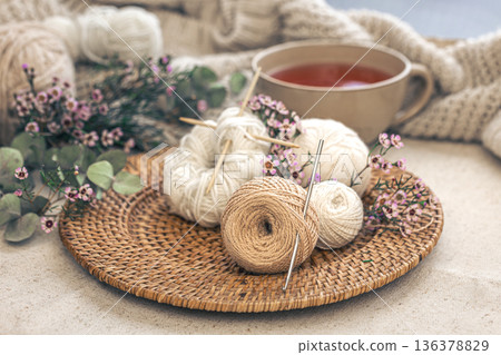 Cozy composition with knitting threads, a cup of tea and flowers. Cozy composition with knitting threads, a cup of tea and flowers. 136378829