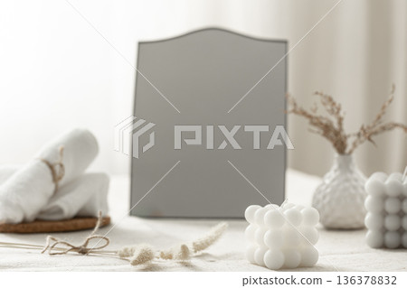 A cozy composition with a mirror and decorative details in a bright room interior. A cozy composition with a mirror and decorative details in a bright room interior. 136378832