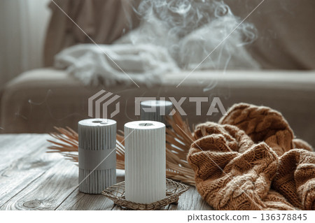 Extinguished candles are smoking on the table in the interior of the room. 136378845