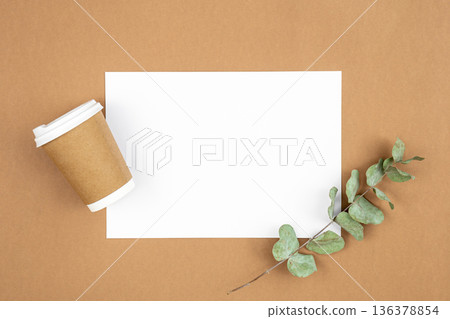 Craft paper coffee cup and eucalyptus sprig on eco background, flat lay. 136378854