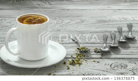 Cup of tea and spoons on a beautiful white wooden background, winter ,autumn Cup of tea and spoons on a beautiful white wooden background, winter ,autumn 136378875