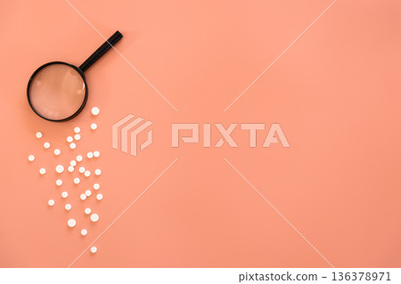 Flat lay, pills and magnifier on pink background, copy space. Flat lay, pills and magnifier on pink background, copy space. 136378971