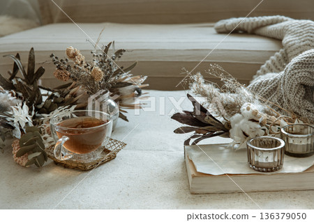 Cozy composition with a cup of tea, dried flowers and decorative elements. Cozy composition with a cup of tea, dried flowers and decorative elements. 136379050