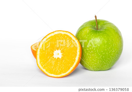 Green apple and orange on a white background isolated. 136379058