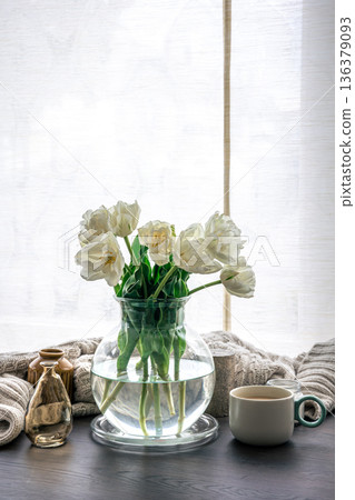 Home composition with a bouquet of tulips in a glass vase and candles. Home composition with a bouquet of tulips in a glass vase and candles. 136379093