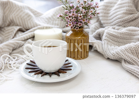 Home composition with a cup of coffee, a candle and a bouquet of flowers. Home composition with a cup of coffee, a candle and a bouquet of flowers. 136379097