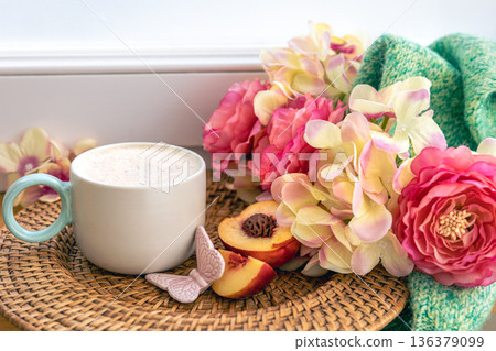 Home composition with a cup of coffee, flowers and a knitted element. 136379099