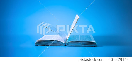 An open book on a blue background. Education background. Back to school. An open book on a blue background. Education background. Back to school. 136379144