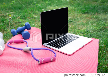 Laptop, water, sports mat and equipment for outdoor training. Laptop, water, sports mat and equipment for outdoor training. 136379164