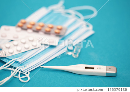 Medical background with thermometer, pills and masks close-up. 136379186