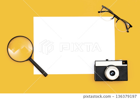 Minimal background with blank paper, camera and magnifier, flat lay. Minimal background with blank paper, camera and magnifier, flat lay. 136379197