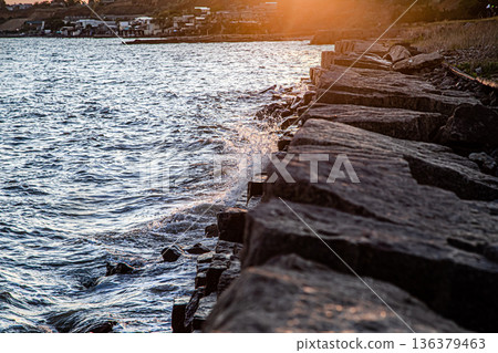 Beautiful sea at sunset near the rocky shore Beautiful sea at sunset near the rocky shore 136379463