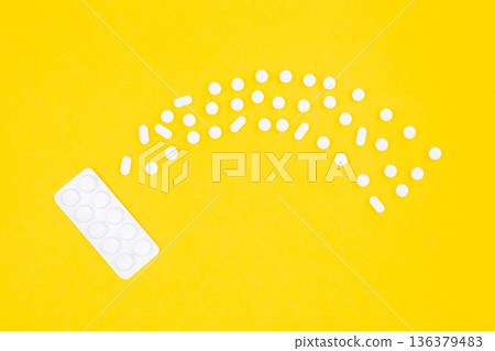 Blister with pills and tablets on a yellow background, flat lay. Blister with pills and tablets on a yellow background, flat lay. 136379483