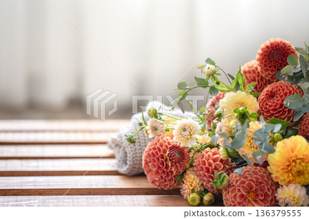 A bouquet of yellow and orange chrysanthemums on a blurred background. 136379555