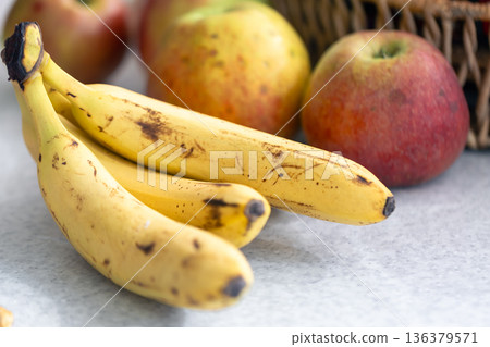 Branch of ripe yellow bananas and apples close-up. Branch of ripe yellow bananas and apples close-up. 136379571