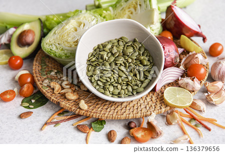 Close-up, a bowl of pumpkin seeds and other healthy foods on the kitchen table. 136379656