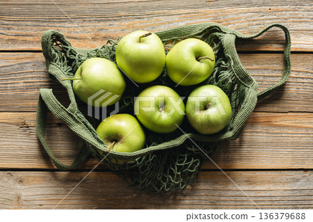 Close-up, green apples in a mesh shopping bag, top view. 136379688