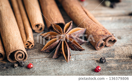 Composition with star anise and cinnamon sticks on a wooden background. 136379806