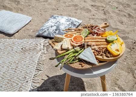 Summer picnic on the sandy beach with many delicacies and tasty treats. 136380764