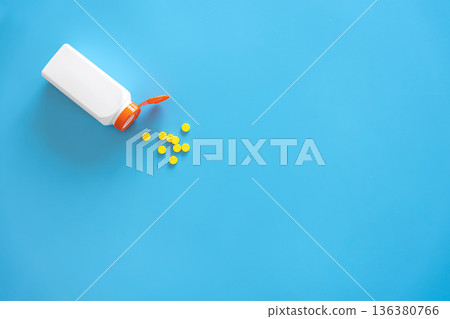 Pills are poured out of a jar on a blue background., flat lay. 136380766