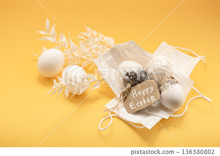 Spring Easter composition with Easter eggs and protective masks close up. 136380802