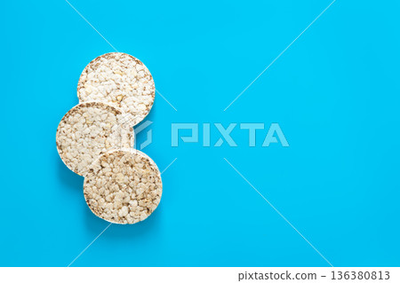 Puffed rice cakes on blue background, flat lay, copy space. Puffed rice cakes on blue background, flat lay, copy space. 136380813