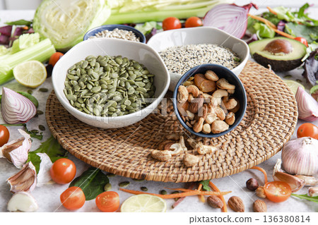 Pumpkin seeds, nuts and chia seeds and other healthy foods on the kitchen table. Pumpkin seeds, nuts and chia seeds and other healthy foods on the kitchen table. 136380814