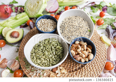 Pumpkin seeds, nuts and chia seeds and other healthy foods on the kitchen table. Pumpkin seeds, nuts and chia seeds and other healthy foods on the kitchen table. 136380815