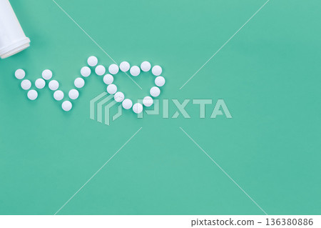 Scattered heart shaped pills on green background, flat lay. 136380886
