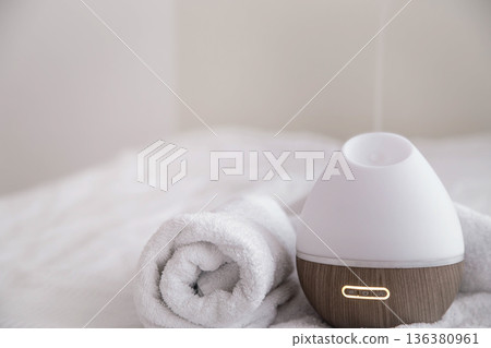 Spa composition with aroma diffuser and towel on a blurred background. 136380961