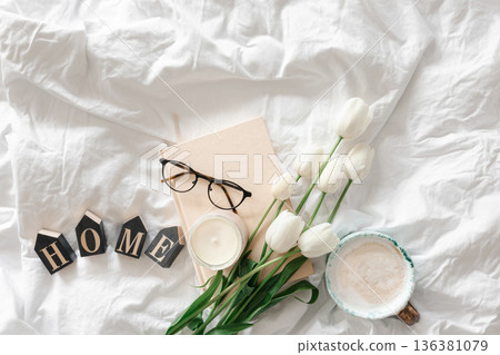 Spring background with a bouquet of flowers, a cup of coffee and a book in bed. Spring background with a bouquet of flowers, a cup of coffee and a book in bed. 136381079