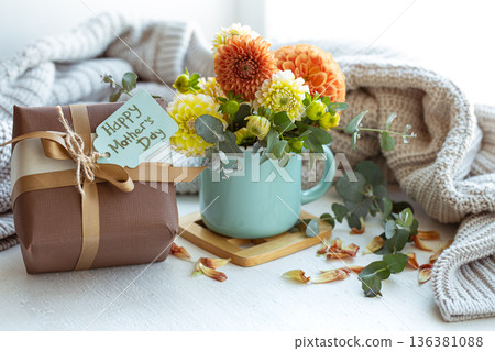 Spring composition for mother's day with a gift and chrysanthemum flowers. 136381088