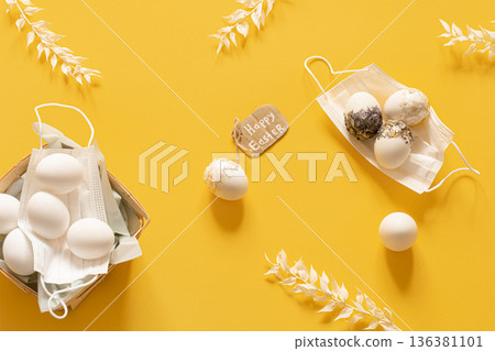 Spring Easter composition with protective masks and scattered Easter eggs top view. Spring Easter composition with protective masks and scattered Easter eggs top view. 136381101