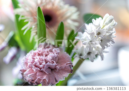 Spring flowers in a vase on a blurred background. Spring flowers in a vase on a blurred background. 136381113