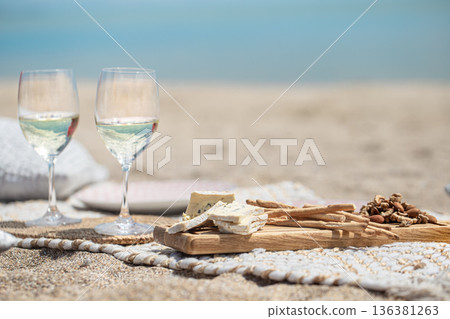 Close up of glasses of champagne and snacks on the seashore copy space. Close up of glasses of champagne and snacks on the seashore copy space. 136381263