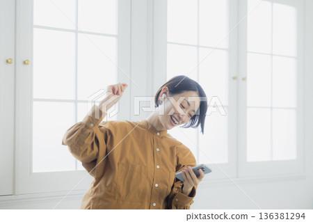 婦女在客廳裡聽音樂 136381294