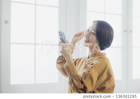 Women listening to music in the living room Women listening to music in the living room 136381295