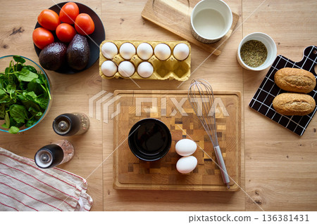 Top View of Kitchen Table with Eggs, Whisk, Bowls, Vegetables and Bread Top View of Kitchen Table with Eggs, Whisk, Bowls, Vegetables and Bread 136381431