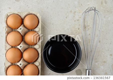 Top view of eggs, whisk and bowl on table Top view of eggs, whisk and bowl on table 136381567