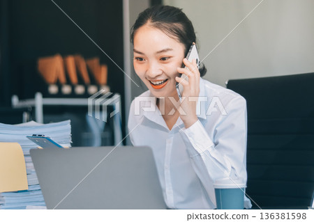 Charming smiling adult woman middle aged woman with curly hair architect designer working on computer in the bright modern office Charming smiling adult woman middle aged woman with curly hair architect designer working on computer in the bright modern office 136381598