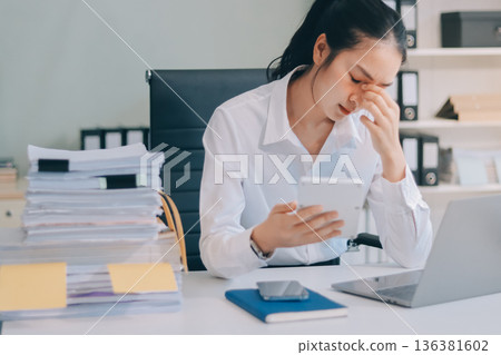 Asian business woman experiences work stress headache in modern office reviewing financial report data analysis overwhelmed professional employee burnout difficult project Asian business woman experiences work stress headache in modern office reviewing financial report data analysis overwhelmed professional employee burnout difficult project 136381602