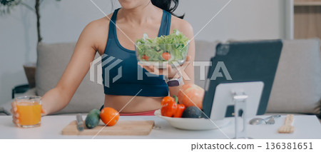 Fit young Asian women in activewear sitting on yoga mat and eating fresh vegetable salad after workout, representing clean eating, fitness lifestyle, wellness routine and health balance. Fit young Asian women in activewear sitting on yoga mat and eating fresh vegetable salad after workout, representing clean eating, fitness lifestyle, wellness routine and health balance. 136381651
